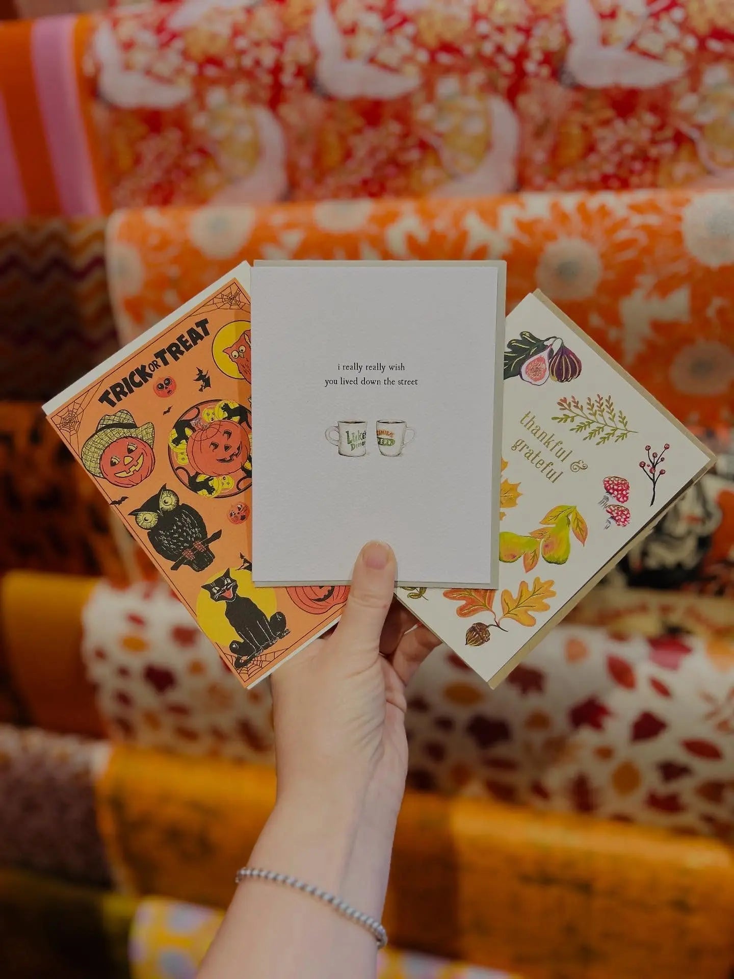 Cute Halloween and Fall greeting cards displayed against a fine paper background.