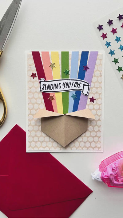 Video displaying how to use paper and stickers to create a handmade card with a Sending You Love sentiment.
