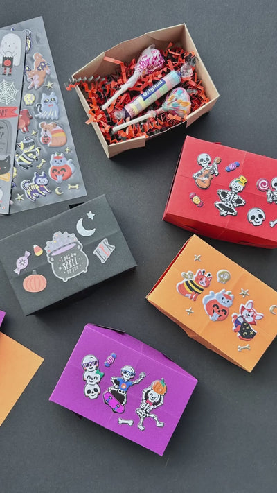 Video showing how to craft cute Halloween treat boxes with paper and stickers.