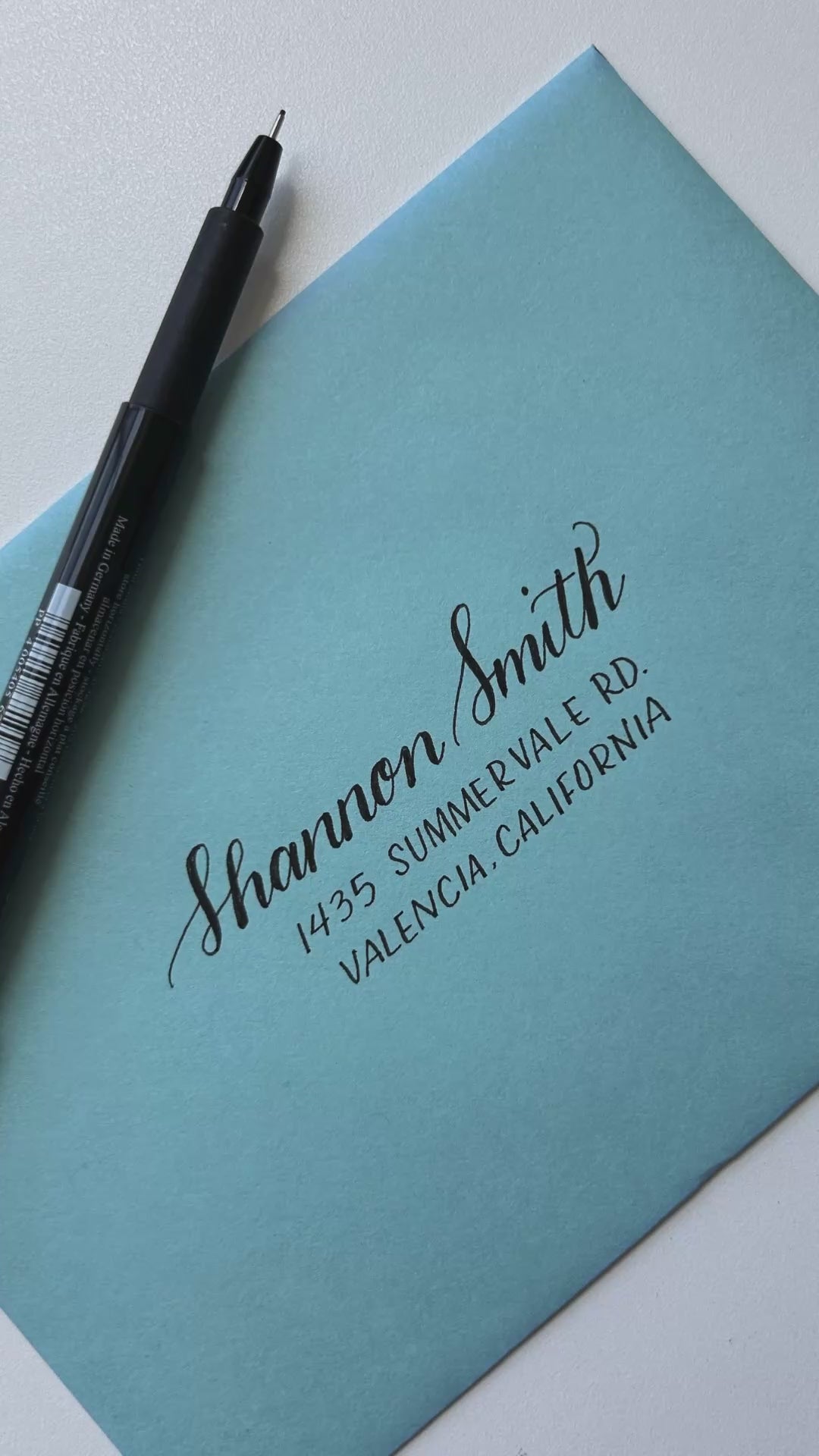 Video showing the process of hand lettering on an envelope.