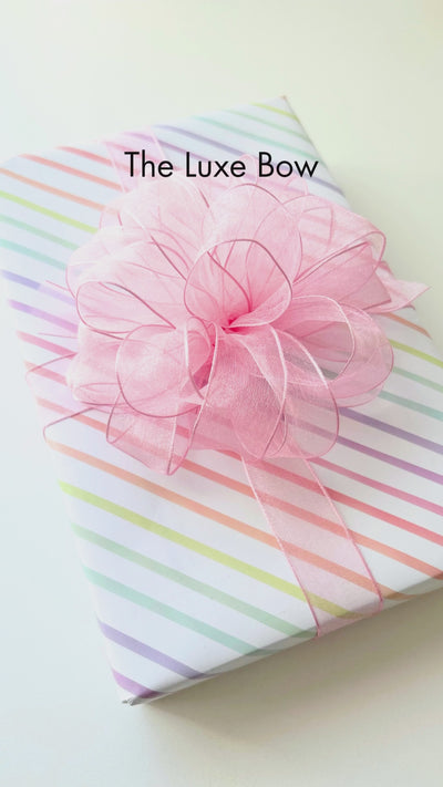 Video detailing how to create a luxe bow gift wrap topper.