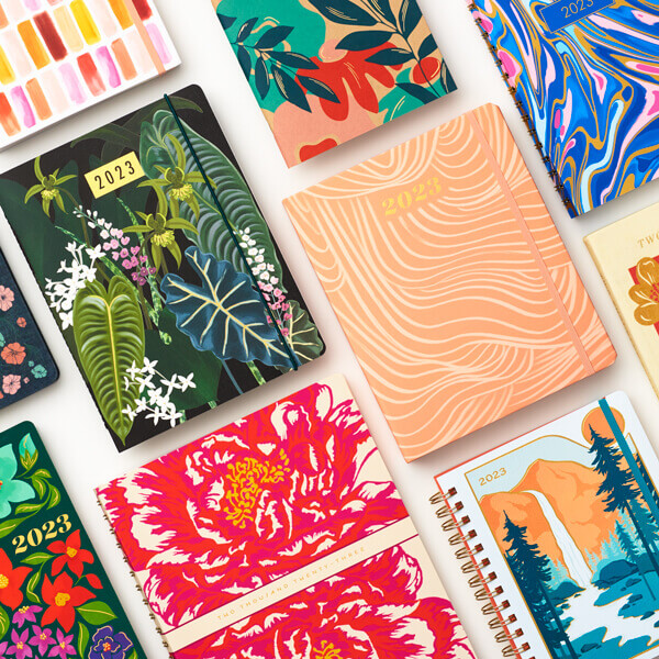 Colorful 2023 planners displaying beautifully illustrated covers.