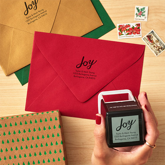 Custom stamp tool displayed next to red, green and gold envelopes with custom impressions.